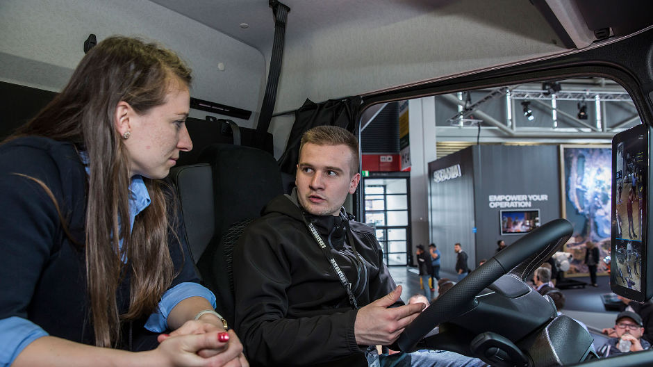 A Martin Radlinski (derecha) ya le entusiasmaban los camiones desde pequeño. Este estudiante de ingeniería de caminos ya tiene toda una batería de preguntas sobre la MirrorCam para Lisa Battenberg, de Mercedes-Benz Trucks.