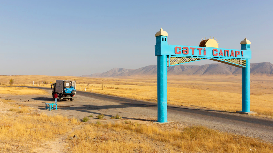 Tässä kazakstanilaisessa kyltissä toivotetaan ”hyvää matkaa”: maailman yhdeksänneksi suurimmassa valtiossa seikkailijakaksikko pääsi näkemään niin kiehtovia antiikkisia paikkoja kuin hermoja raastavan huonokuntoisia teitäkin.